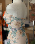 Floral dress on a mannequin with a blurred indoor background