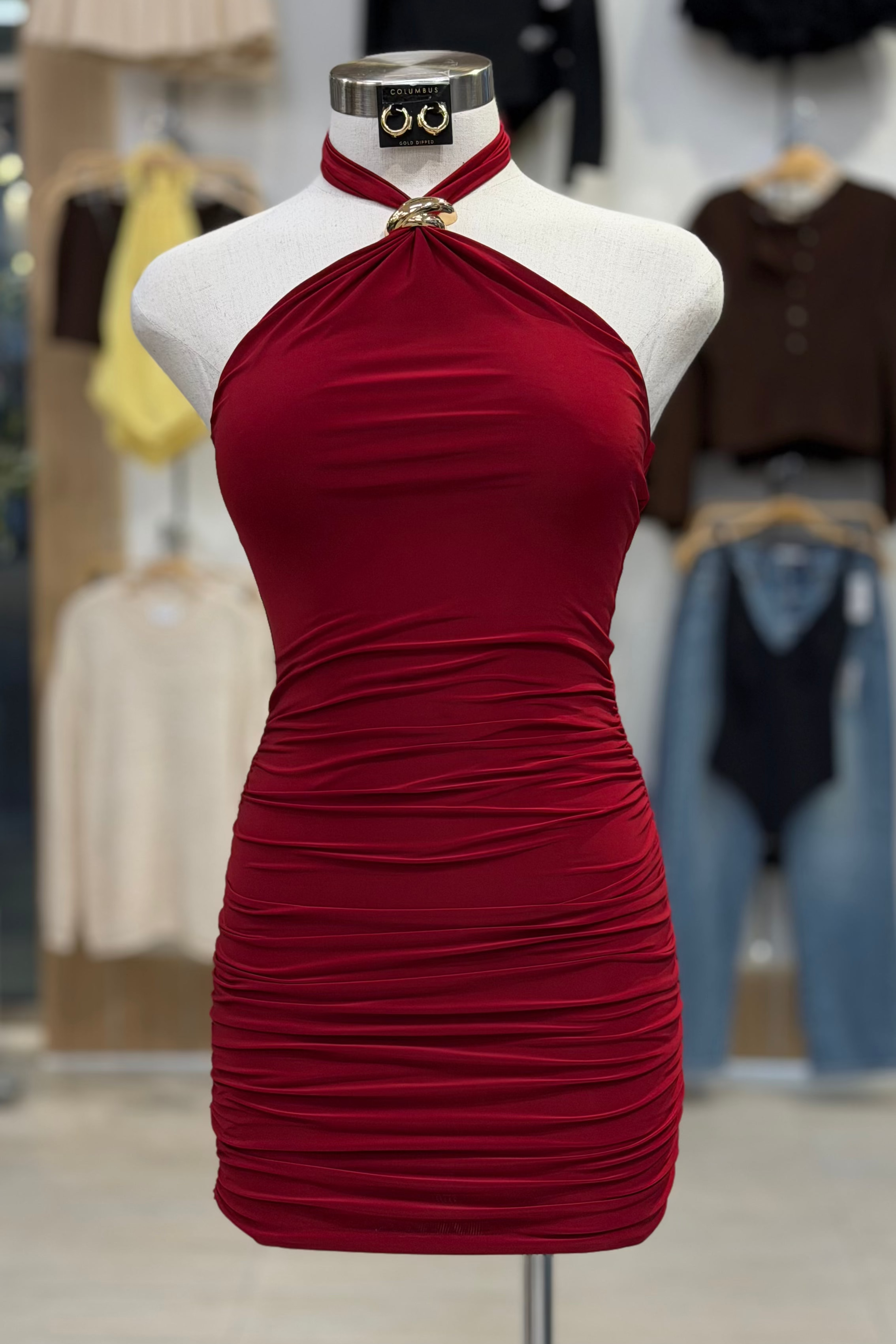 Red halter dress on a mannequin in a store setting