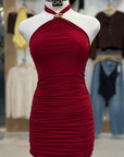 Red halter dress on a mannequin in a store setting