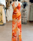 Orange and beige floral dress on a mannequin in a clothing store.
