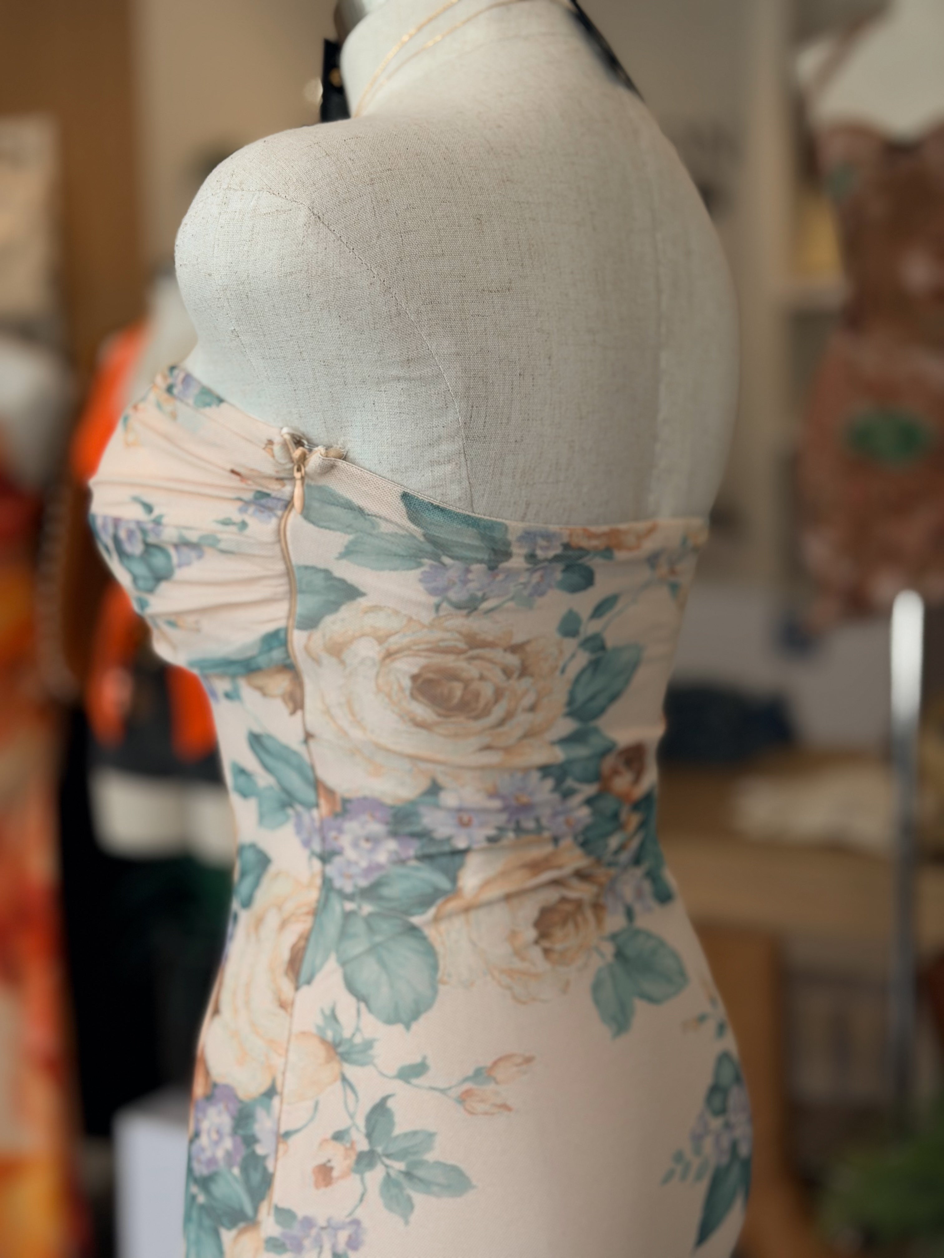 Floral dress on a mannequin with a blurred indoor background