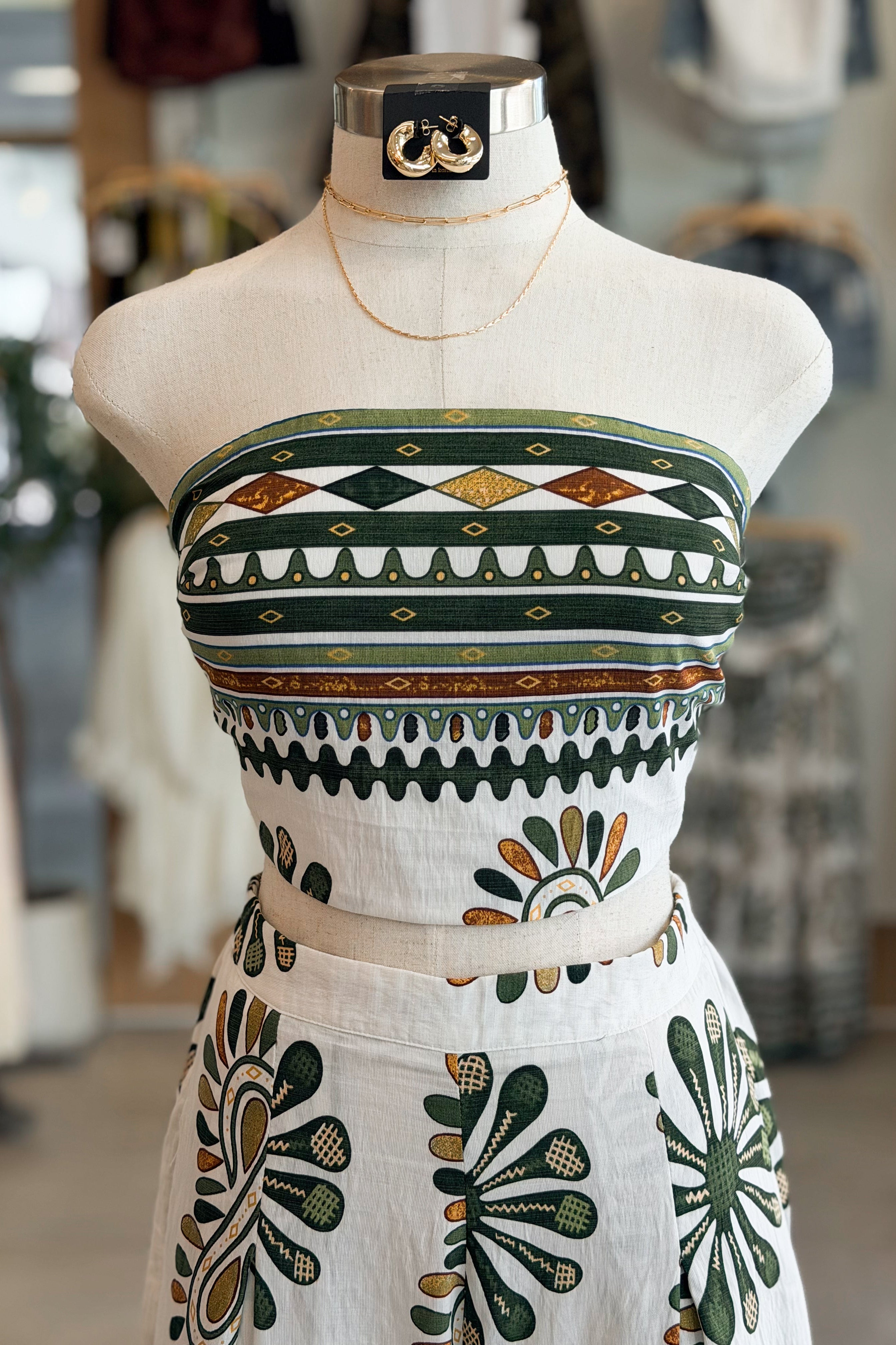 Mannequin wearing a strapless dress with geometric pattern in a store setting