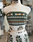 Mannequin wearing a strapless dress with geometric pattern in a store setting