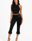 Model in black Mira halter crop top and capri pants with O-ring detail